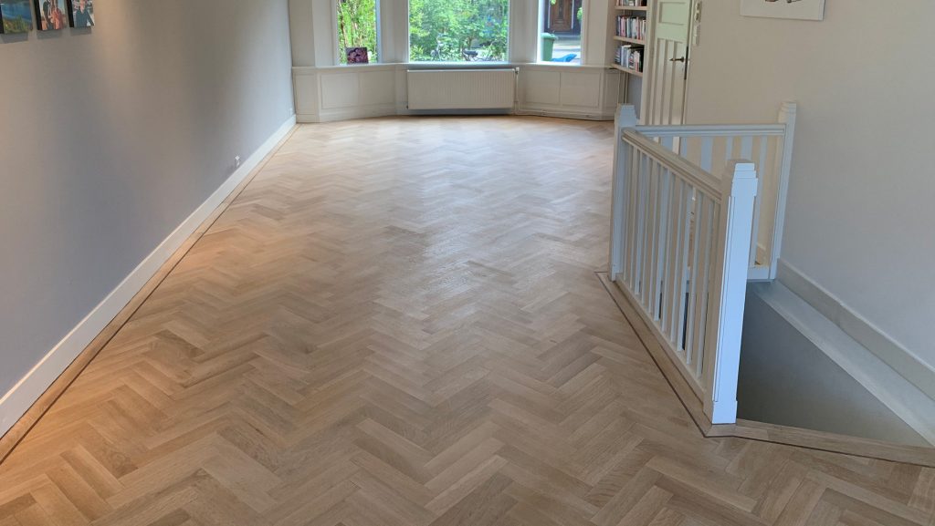 De 'onbehandelde' lak is erg populair, hier te zien op een chique visgraat vloer.