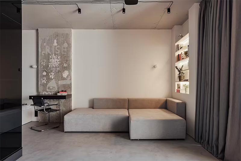 Scapes Concept Studio heeft deze moderne industriële woonkamer ingericht met een combinatie van strakke witte muren en een grijze beton ciré vloer.