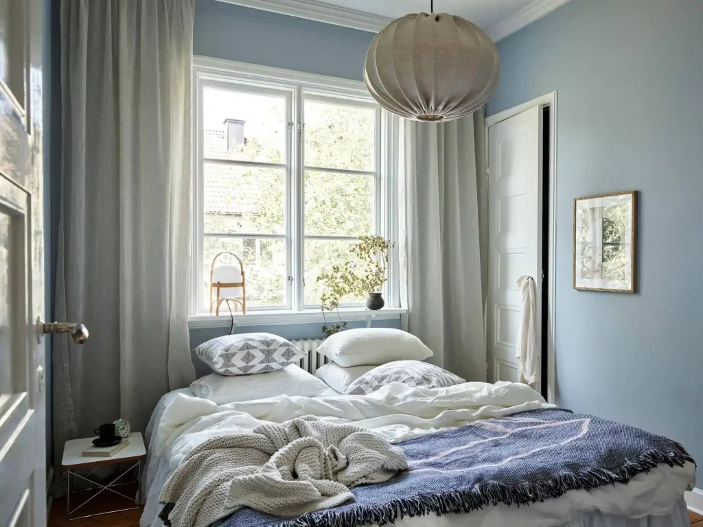 Een mooie combinatie van lichtblauwe muren en neutrale tinten in deze lichte Scandinavische slaapkamer.
