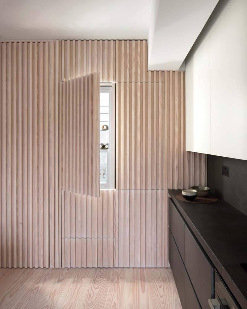 Blinde deuren kan je ook toepassen op de deuren van kasten. In dit stijlvolle appartement, ontworpen door architectuurstudio Proctor & Shaw, is de koelkast voorzien van een blinde deur.