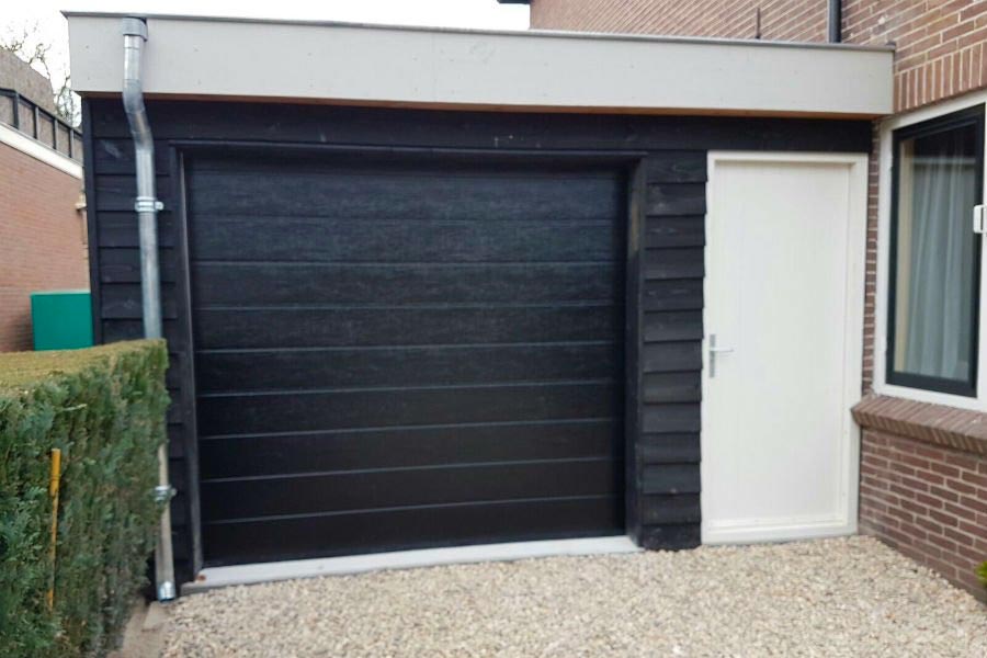 Naast een garagedeur, heeft deze aanbouw ook nog een aparte ingang. | Bron: Boha.nl