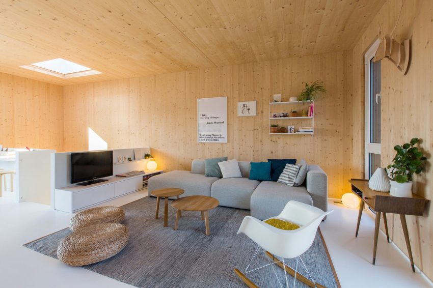 De ontwerpers van Spotless Architecture kozen voor een moderne grijze hoekbank met chaise longue in deze warme en knusse woonkamer. Klik hier voor meer foto's.