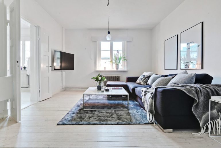 De zithoek in deze Scandinavische woonkamer is afgemaakt met een super leuk vloerkleed. Klik hier voor meer foto's.