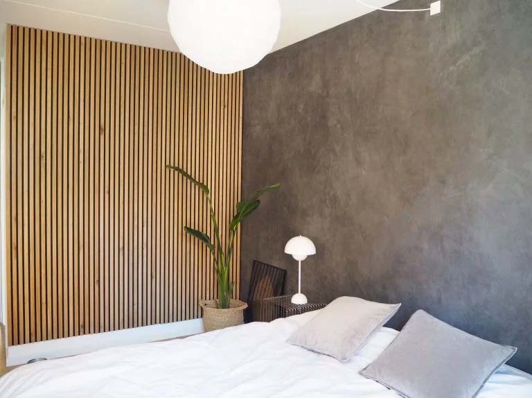 Ook in de slaapkamer is het een goed idee om een mooie houten panelen muur te plaatsen - hier gecombineerd met een betonlook muur.