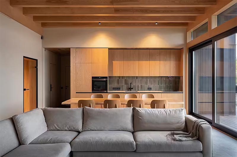 Klochenko Architects heeft voor deze nieuw gebouwde woning gekozen voor een prachtig houten plafond met houten balken in de woonkamer. | Fotografie: Alexander Angelovskiy