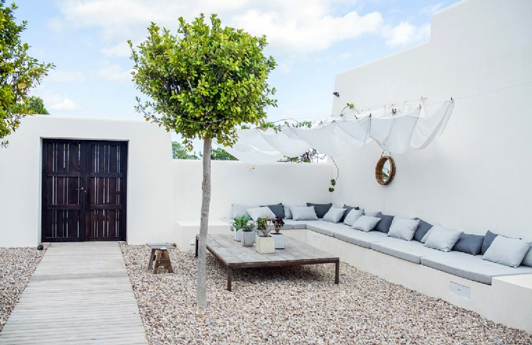 Het grote deel van deze prachtige Ibiza tuin is bedekt met grind, gecombineerd met mooie looppaden van. houten vlonders.