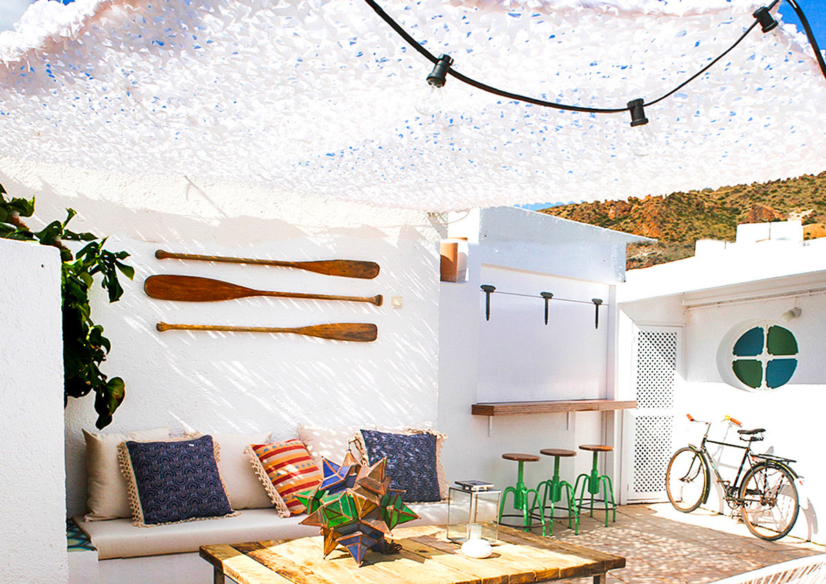 De loungehoek van deze fijne Ibiza tuin is een heerlijke schaduwplek, terwijl de lichtsnoer voor een gezellige sfeer zorgt in de avonduren.