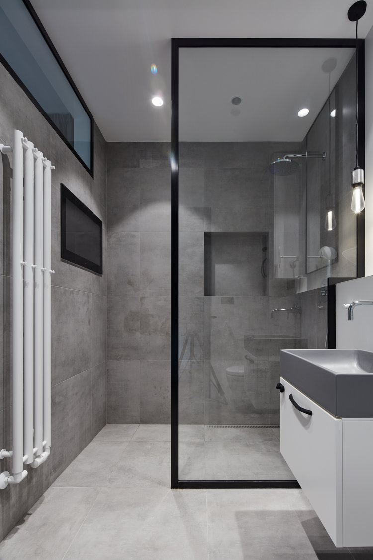 In deze kleine stoere badkamer kan je TV kijken vanuit de douche!