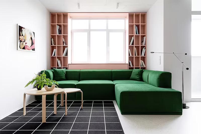 Niola is een appartement met een bijzonder minimalistisch interieur, ontworpen door Ater.Architects. Achter de bank is een roze inbouwkast gerealiseerd als ombouw van het raam. De inbouwkast bevat boekenkasten, maar ook een radiatorombouw.