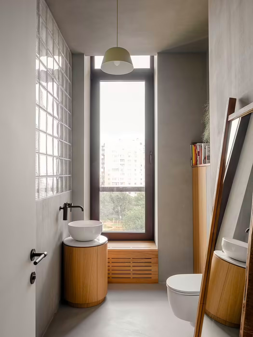 Een modern Japans badkamerontwerp met een betonnen vloer en wanden, gecombineerd met houten meubels.
