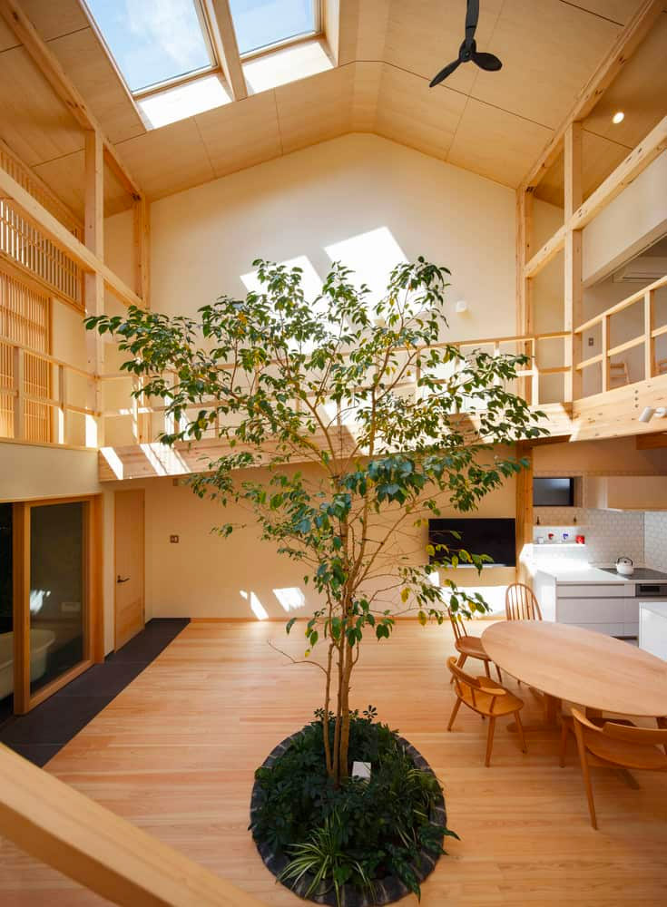 Japans huis in Kyoto is ontworpen door 07BEACH. Naast de wijd open indeling van het huis zelf, is het meest opvallende aspect van dit huis absoluut het feit dat er in het midden een boom groeit! Deze functie was multifunctioneel. De eerste reden om de boom op te nemen was voor esthetische en energetische doeleinden; de groene bladeren voegen een kleuraccent toe aan het verder voornamelijk natuurlijke houtschema en de algehele aanwezigheid van de boom helpt een bijna spa-achtige sfeer te creëren in de primaire kamer en overal met uitzicht erop. | Fotografie: Yosuke Ohtake