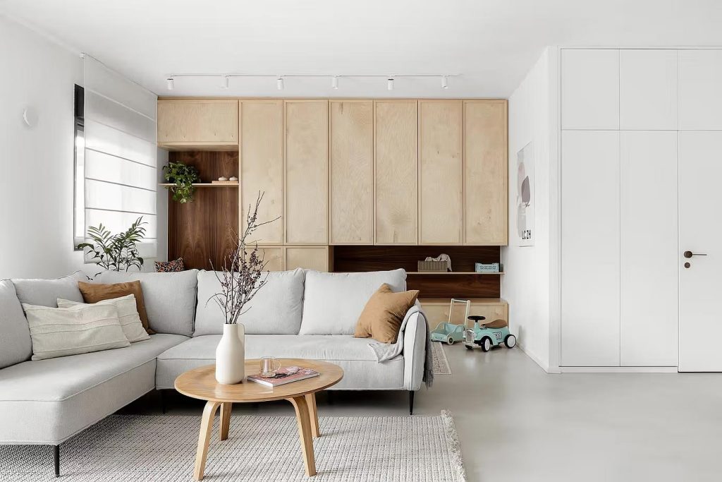 Sharon Kenett heeft deze moderne l-vormige woonkamer ontworpen, met een speelhoek achter de bank. De op maat gemaakte wandkast ziet er niet alleen erg mooi uit, maar biedt ook veel opbergruimte. | Fotografie: Oren Amos