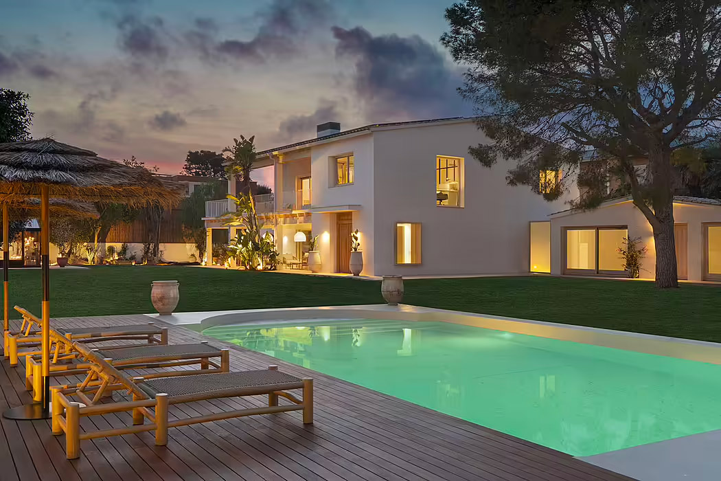 De super mooie Ibiza tuin van Ibiza Spring, een prachtig huis met twee verdiepingen ontworpen door Susanna Cots Interior Design. Groene gazons zijn gecombineerd met houten vlonders rondom het mooi verlichte zwembad. | Fotografie: Mauricio Fuertes