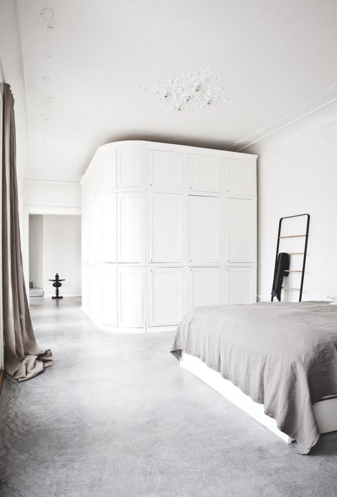 De grijze betonlook vloer en strakke witte muren vormen de basis in dit prachtige Deense appartement. Klik hier voor meer foto's.