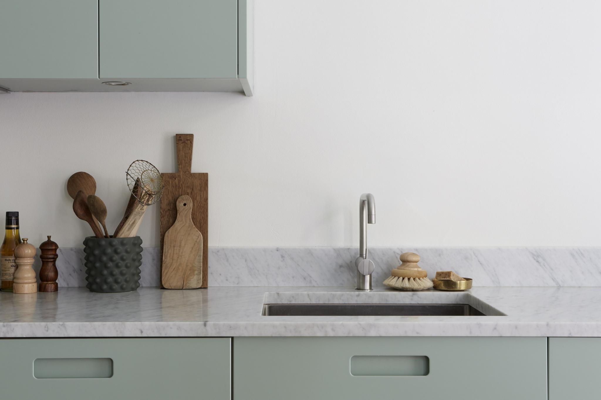 Moderne mintgroene keuken met een marmeren werkblad