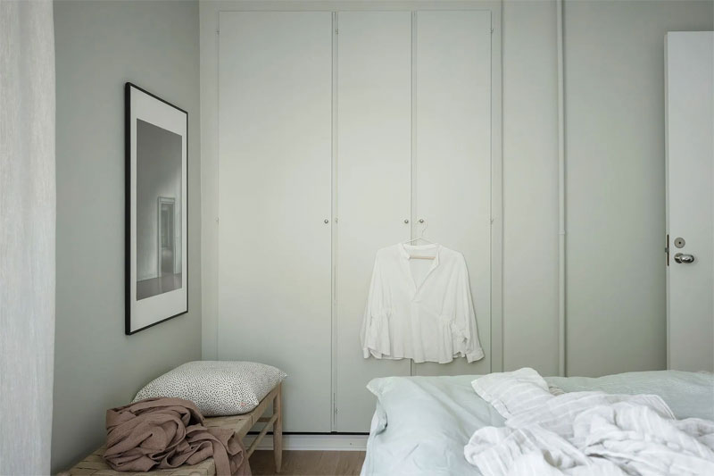 In deze mooie slaapkamer is de inbouwkast met de zelfde mintgroene verf geschilderd als de mintgroene muur.
