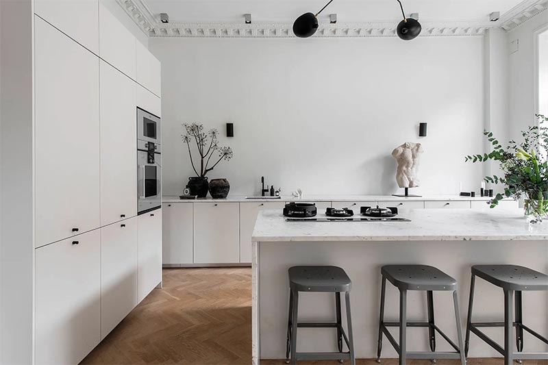 Heb je een hele ruime keuken, dan heb je meer mogelijkheden als het gaat om de opstelling. In deze luxe keuken is gekozen voor een combinatie van een hoge kastenwand, lage keukenkaten én een kookeiland met barkrukken. Heb je een hele ruime keuken, dan heb je meer mogelijkheden als het gaat om de opstelling. In deze luxe keuken is gekozen voor een combinatie van een hoge kastenwand, lage keukenkaten én een kookeiland met barkrukken.