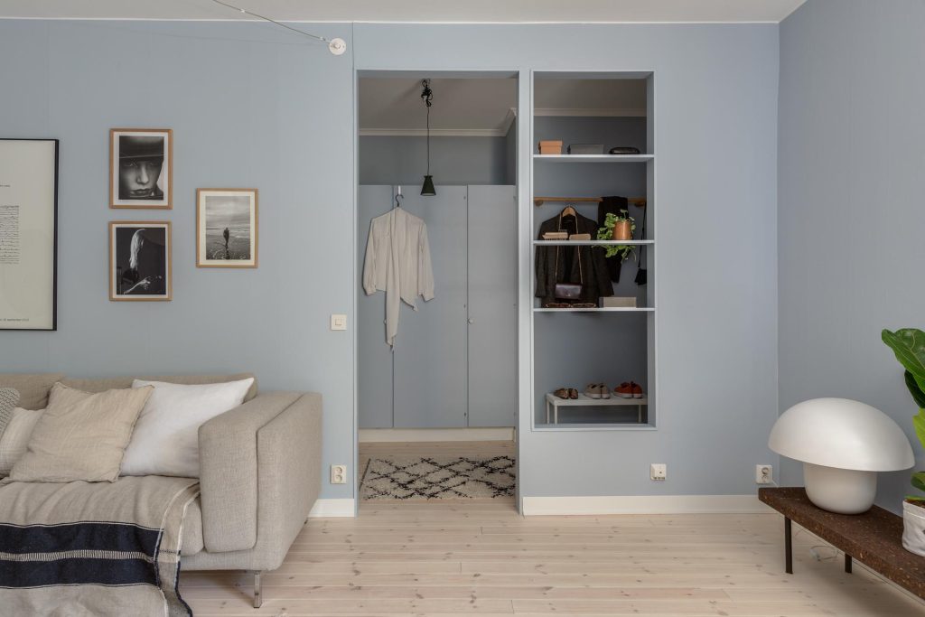 De blauwe pastel muren zorgen voor een meer frisse uitstraling in deze donkere woonkamer.