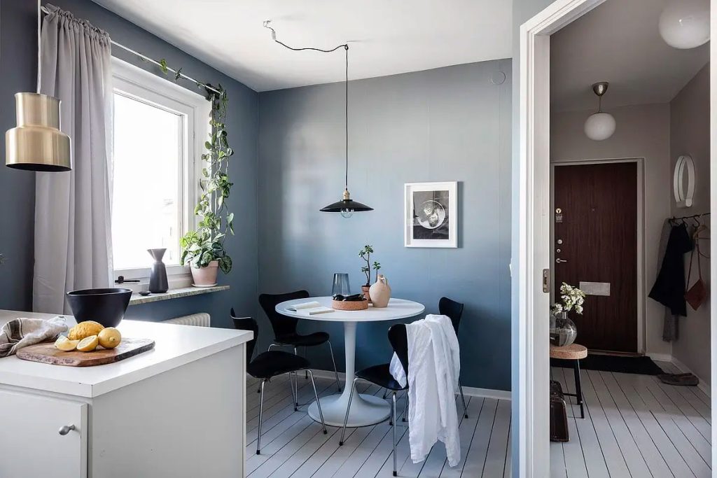 De petrol kleur muren staan super mooi bij de witte houten vloer en de moderne witte keuken.