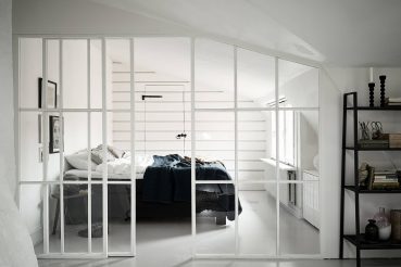 Slaapkamer met een glazen wand met stalen witte kozijnen