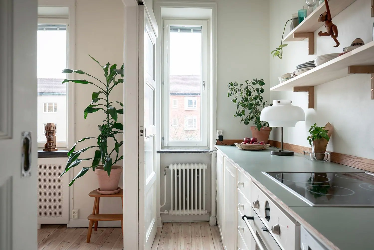 Door de dubbele schuifdeuren op te schuiven, verander deze smalle keuken in een ruimtelijke open keuken!