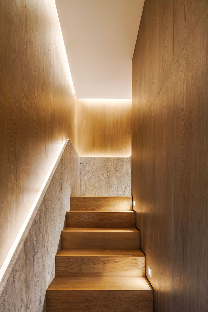 De combinatie van led-strips in de trapleuning, in het plafond en inbouwspots in de wanden boven de traptreden zorgen voor een luxueuze sfeer - ontworpen door Mason Studio.