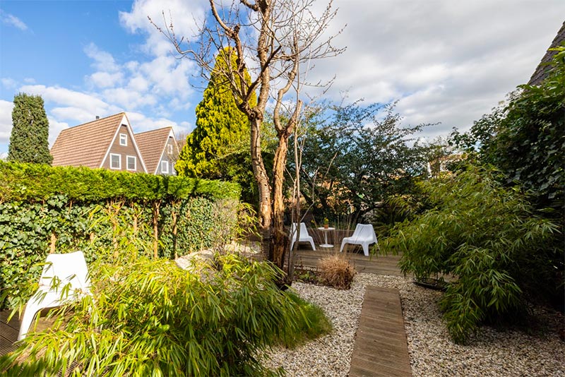 In deze tuin is een tuinpad van houten vlonders gecombineerd met grind.