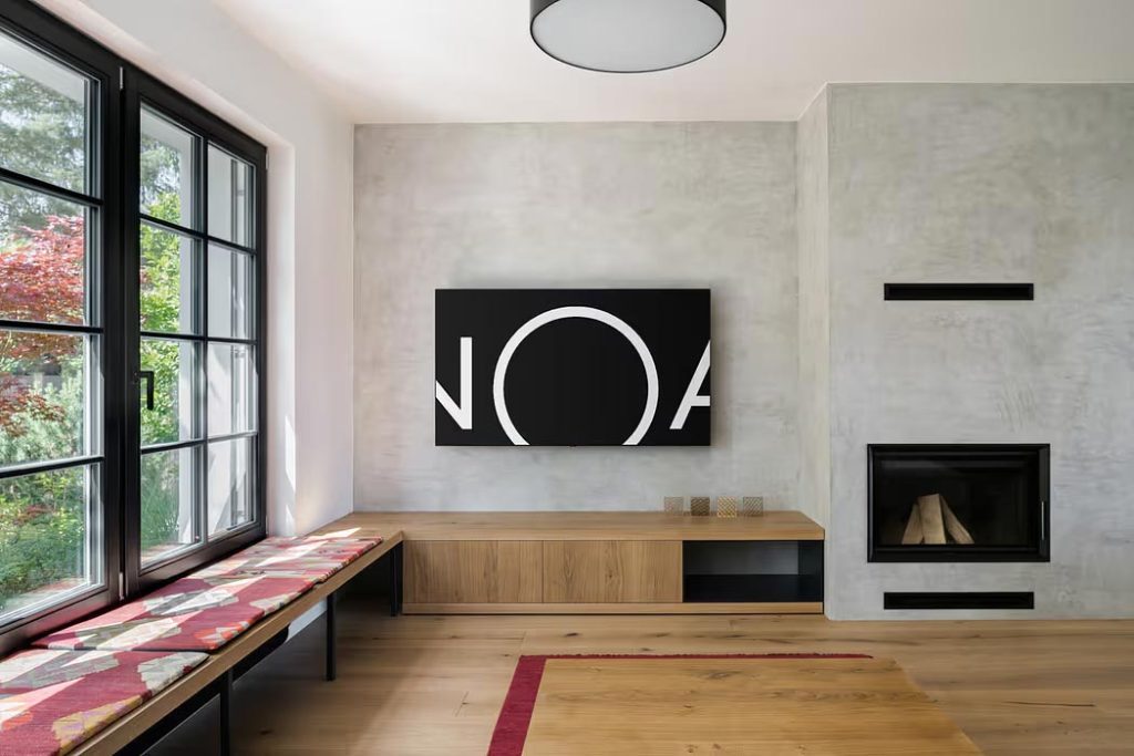 tv aan betonstuc muur houten meubel