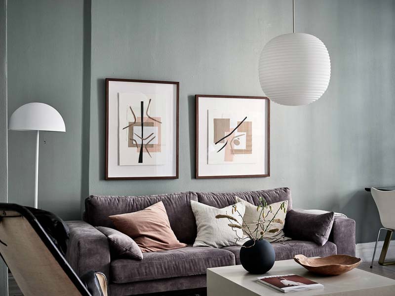 twee schilderijen naast elkaar boven de bank