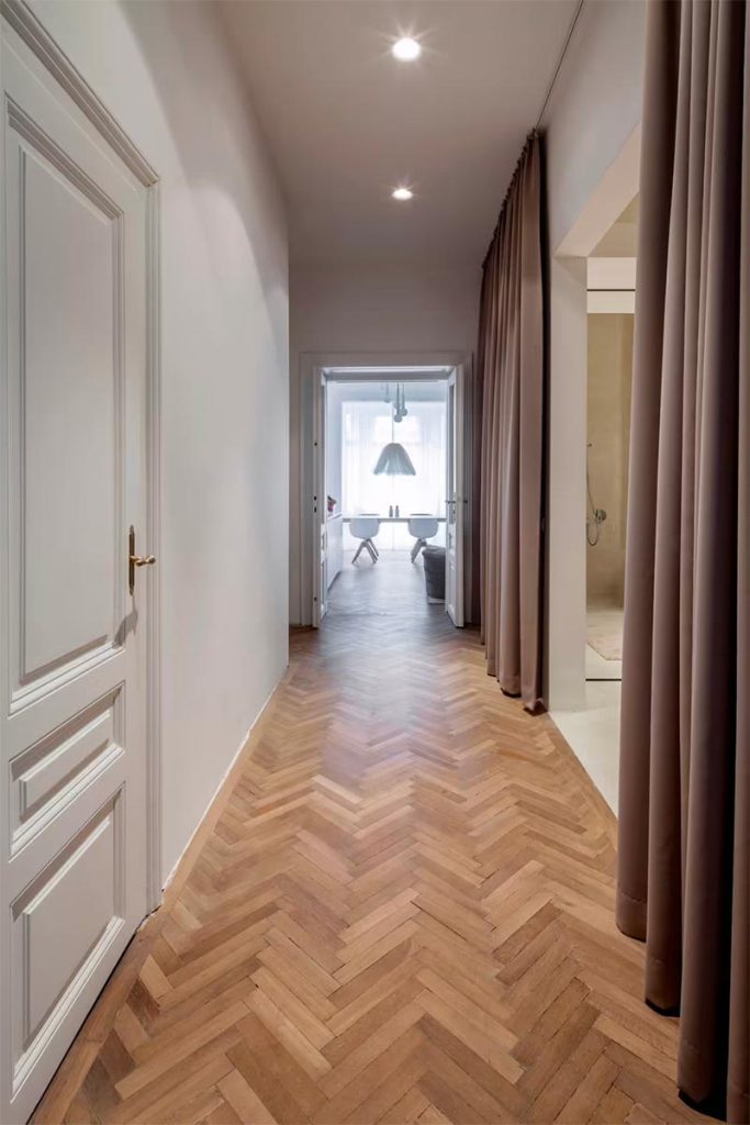 In dit chique appartement heeft Destilat gekozen voor een gespijkerde visgraat houten vloer. | Fotografie: Monika Nguyen