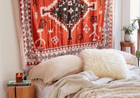 Groot vintage vloerkleed aan de muur boven het bed