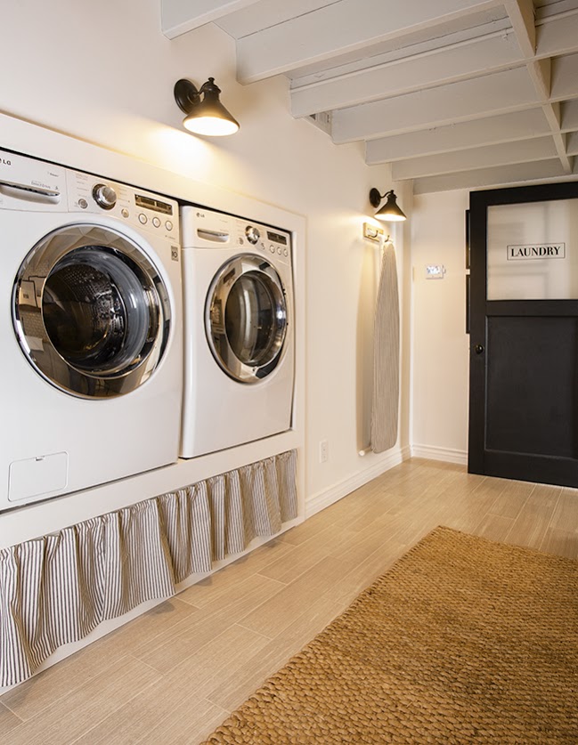 In deze washok, is een maatwerk verhoger gecreëerd, waar zowel de wasmachine als droger naast elkaar op sta-hoogte geplaatst kunnen worden.