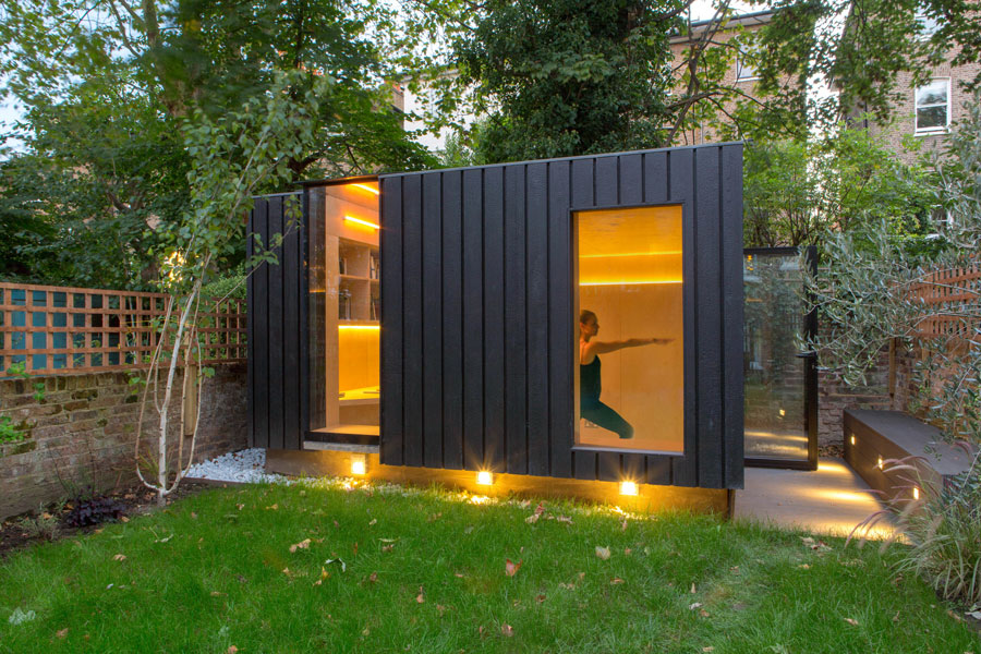 Dit tuinhuisje in de tuin, ontworpen door Neil Dusheiko, wordt gebruikt als kantoor en yoga studio.