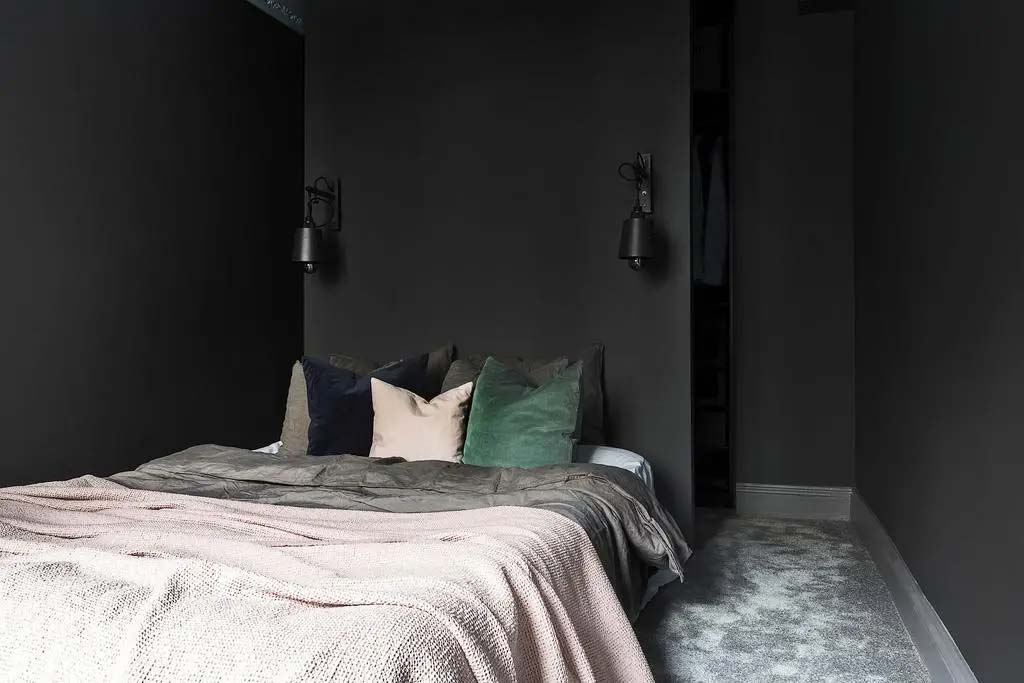 zwarte slaapkamer met inloopkast achter bed