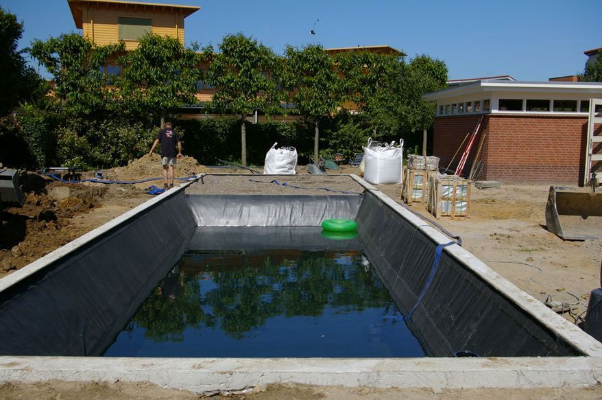 Hier is Zwemvijver Expert bezig met de verwarming met een strakke natuurlijke zwemvijver. | Zwemvijverexpert.nl